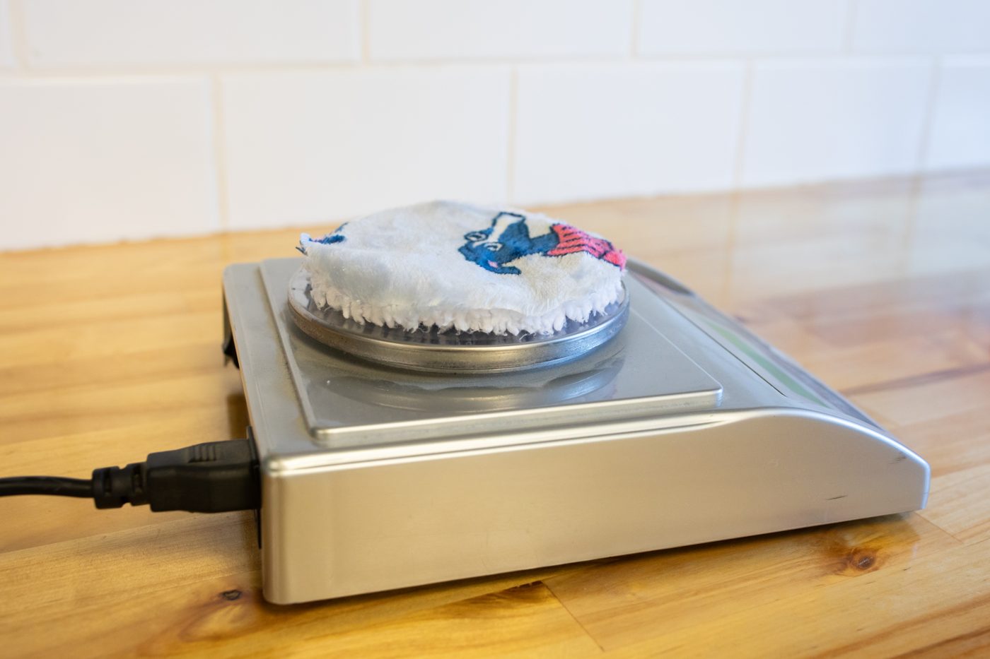 The Oodie fabric swatch being weighed on a gram scale